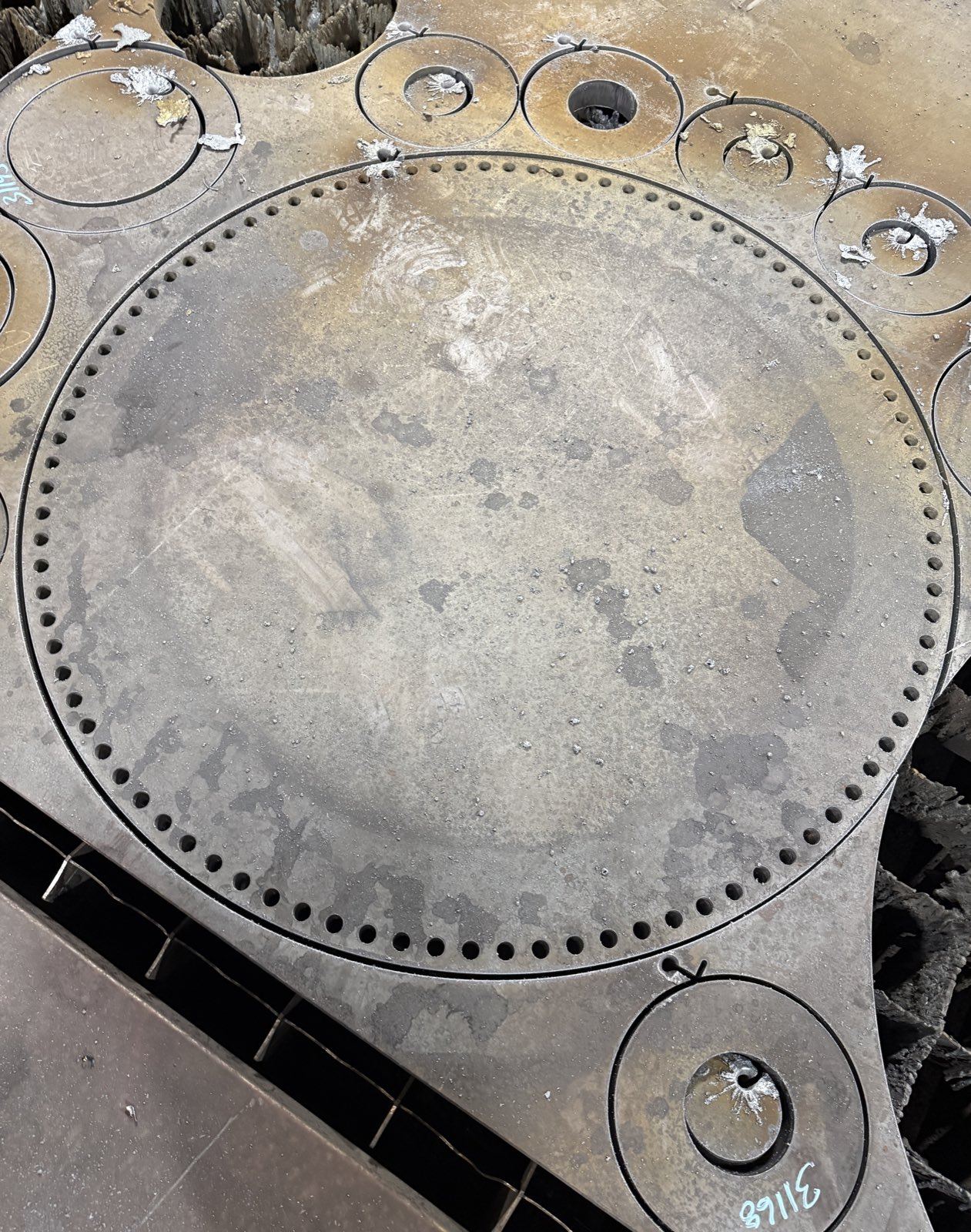 Burned circular plate with a drilled bolt-hole circle