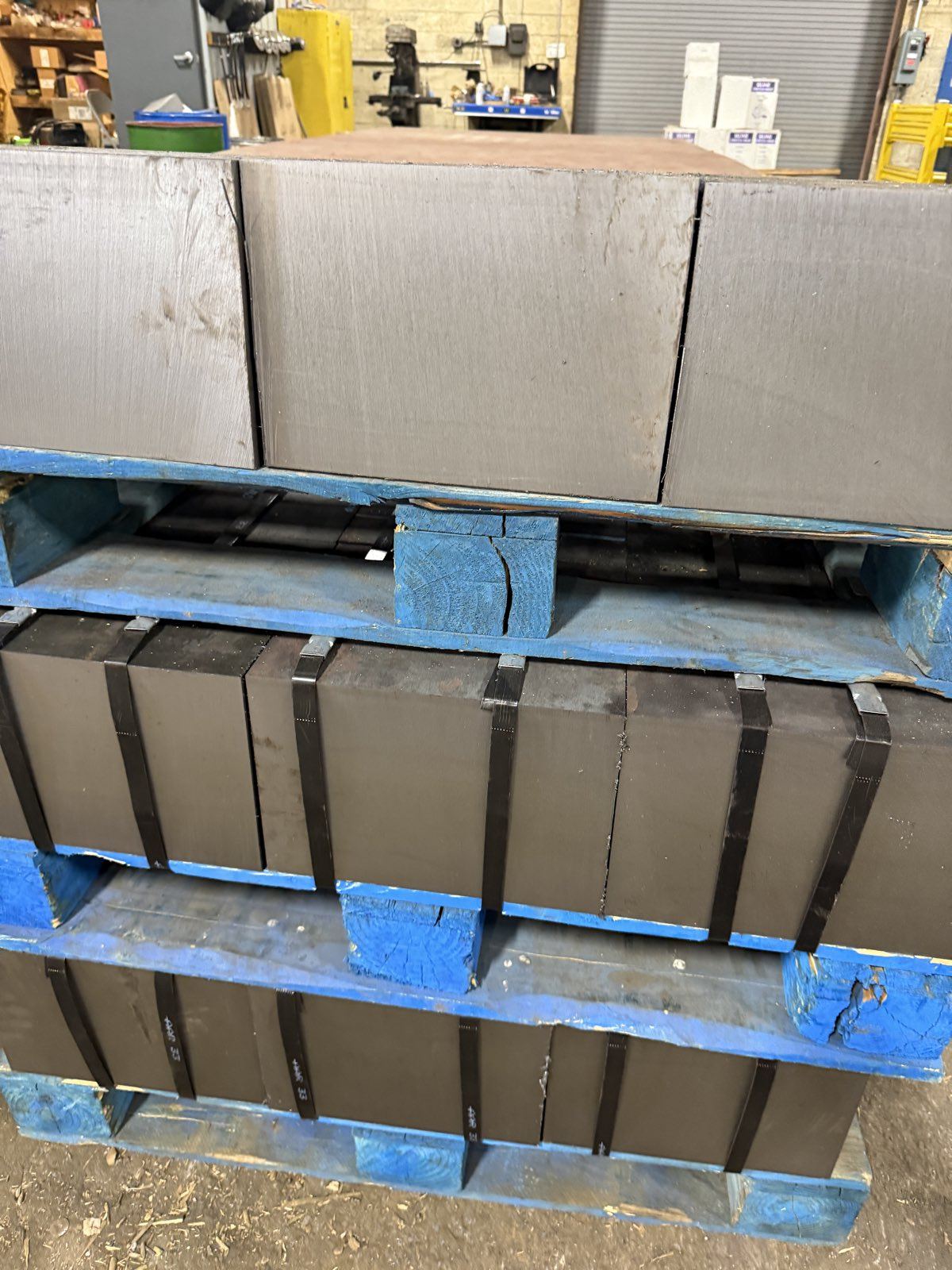 Saw-cut steel plate blocks banded on stacked pallets