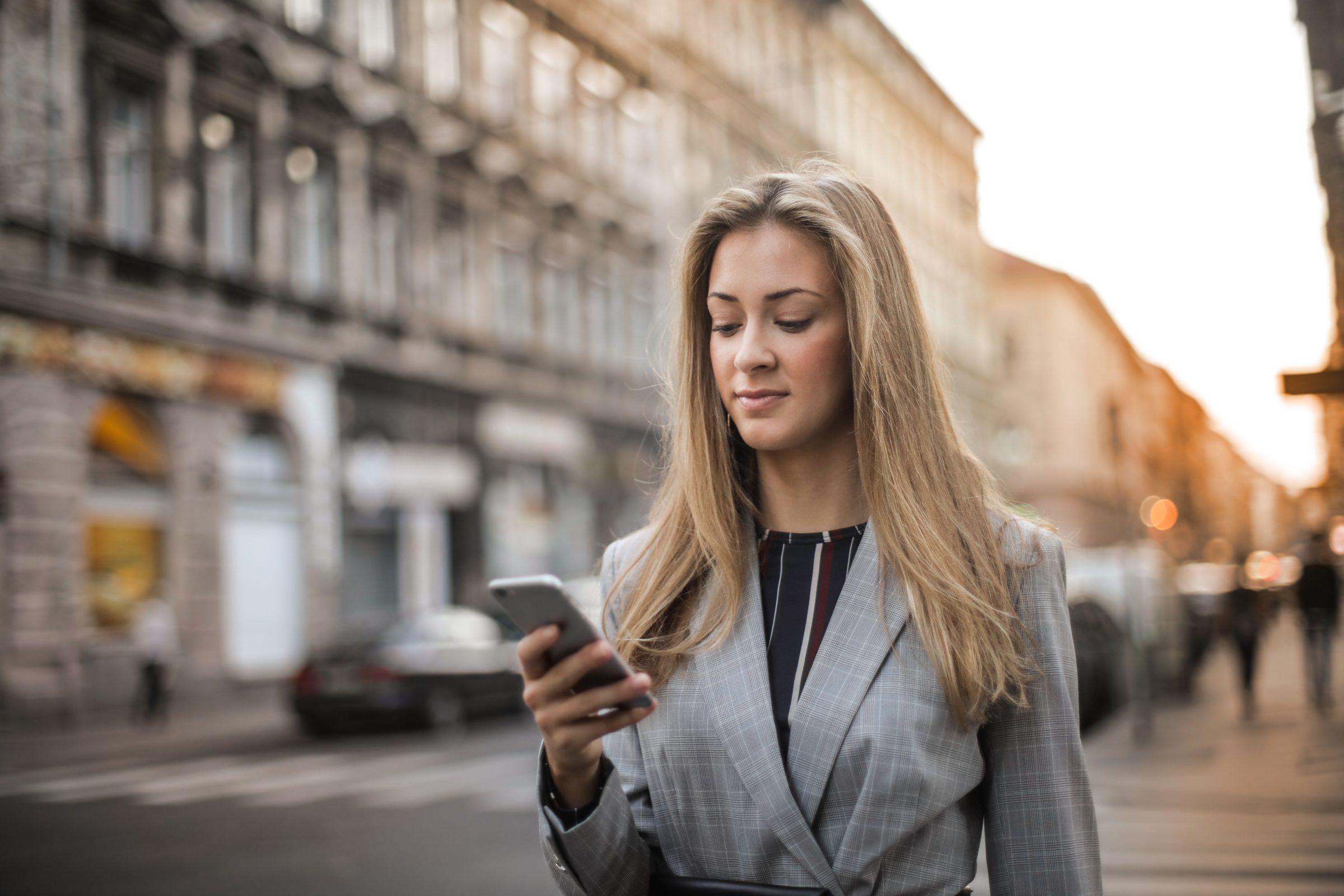 A leasing professional checking their phone while walking a property