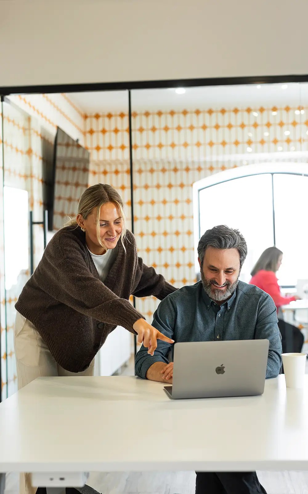 Two colleagues collaborating at a laptop